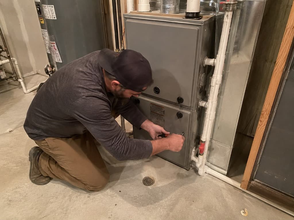 Airnet HVAC technician performing heating system repair and furnace diagnostic check
